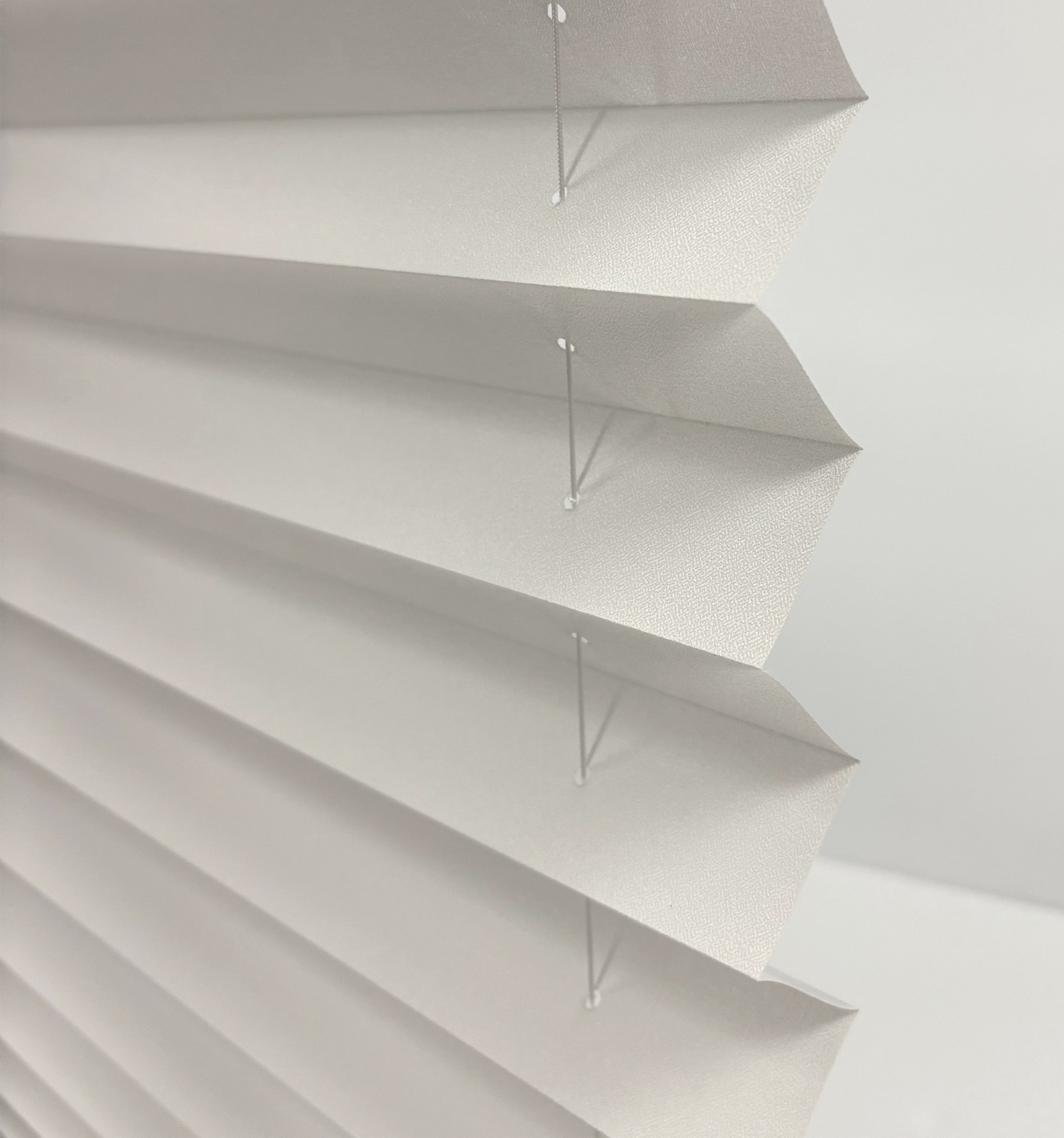 Side view of pleated fabric. Some light will pass through the small holes needed for the support ladder.