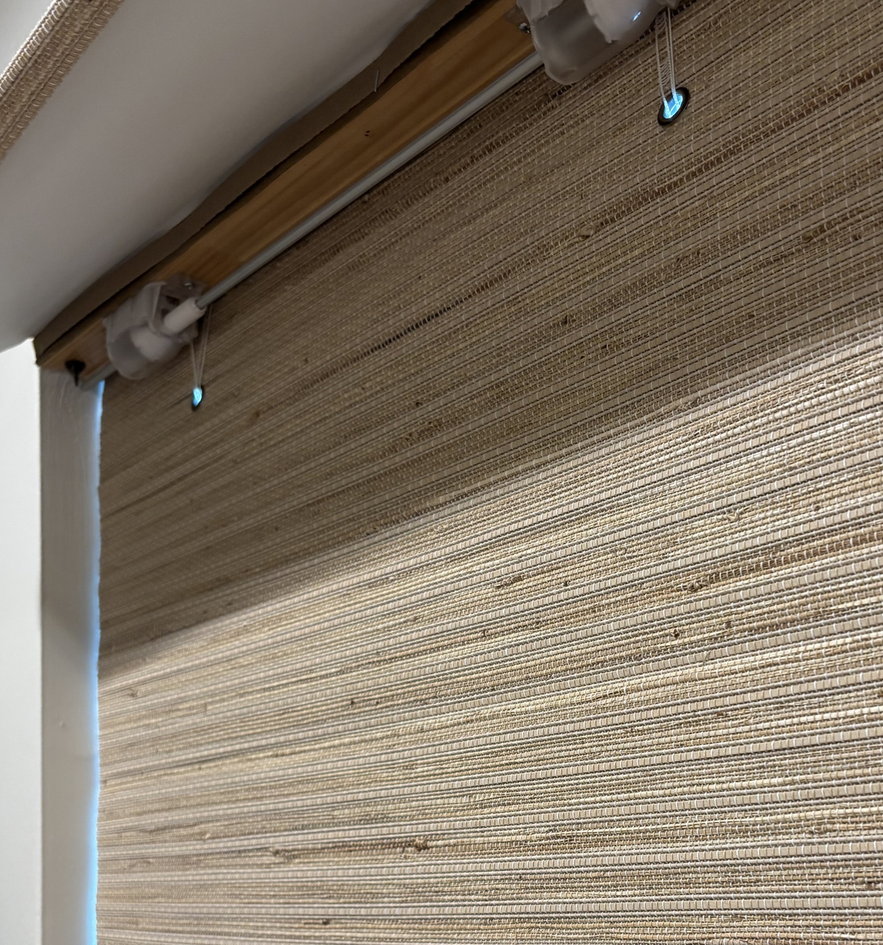 View of cordless mechanism under valance. For blackout shades, some light will pass through the circular eyelets which may cause a soft glow. 