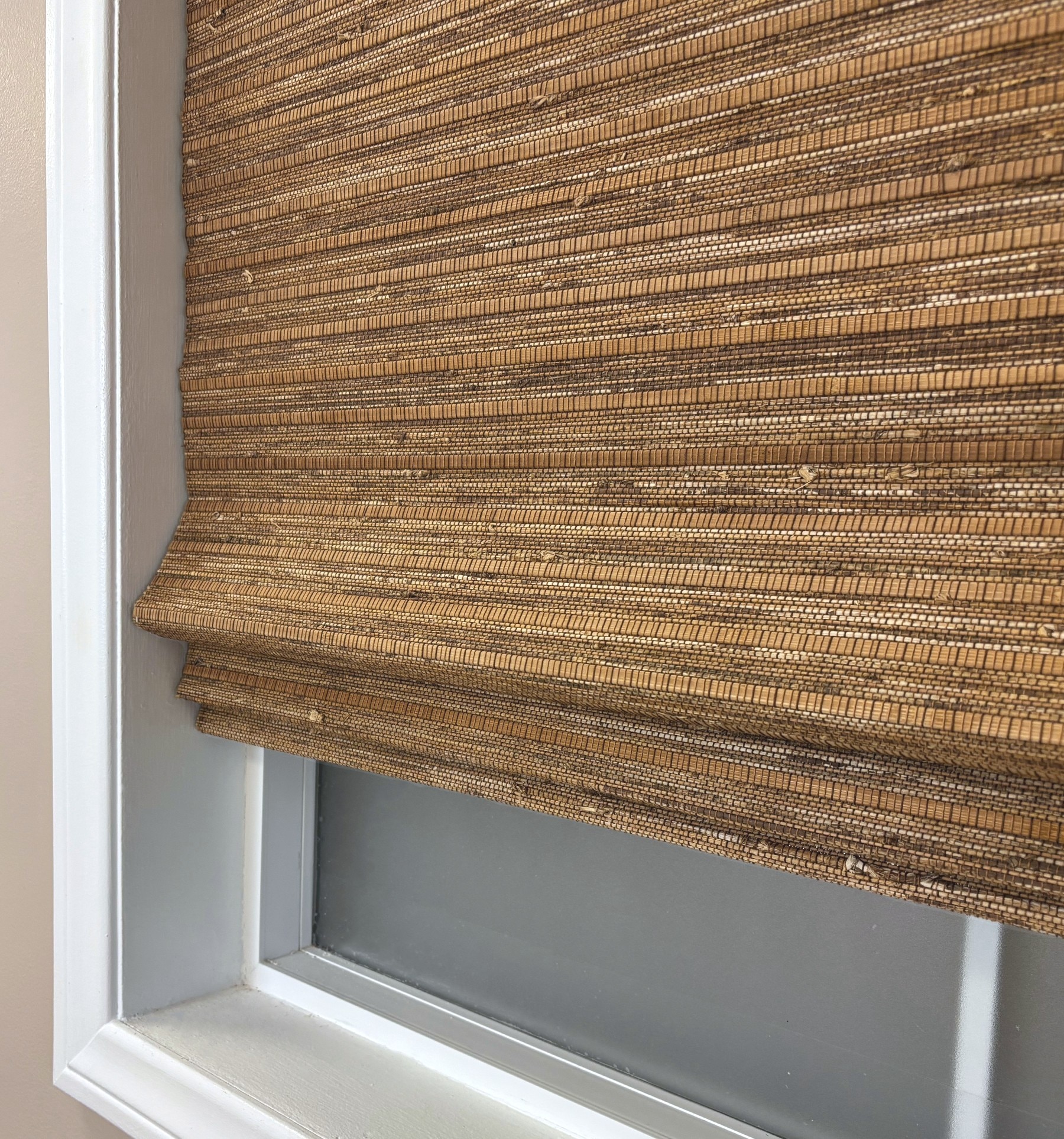 Cordless and Motorized woven shades will gently stack when raised and unfold when lowered.