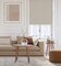 A contemporary living room with smart motorization taupe textured cordless blackout roller shades in tall window
