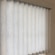 Close up of tilted free hanging fabric vertical vanes and headrail. Shown in Flaxen Light Gray